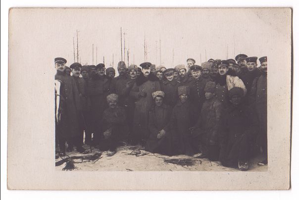 A large crowd of soldiers and officers group together to be photographed.  A few hardy souls kneel in the snow at the front of the group.